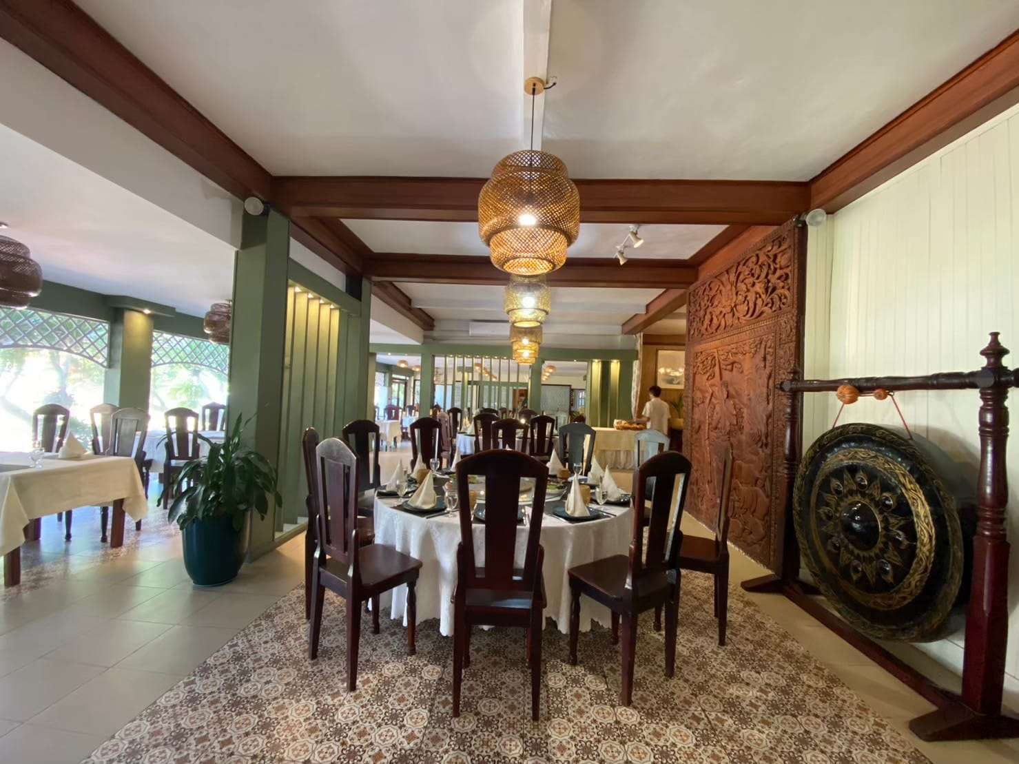 Dining room at Tamnak Lao Restaurant, Vientiane, with traditional Lao wood carving and lantern lighting